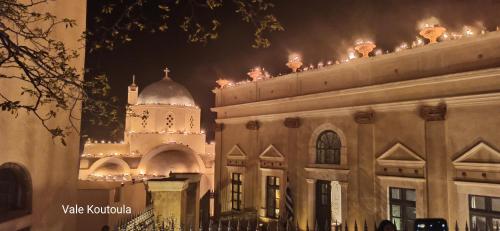 a building with a clock tower at night at Angels Villa Santorini in Megalokhori