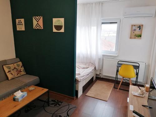 a small living room with a bed and a window at Munteniei - The Sunset Studio in Hunedoara
