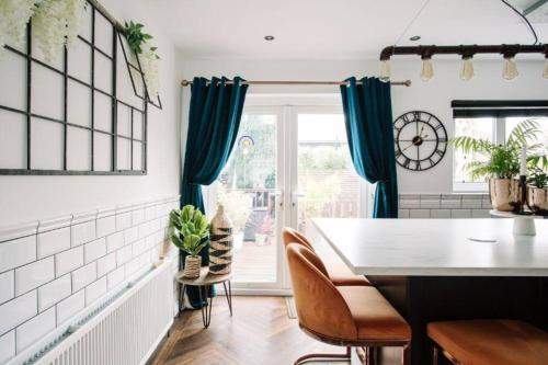 a kitchen with blue curtains and a table and chairs at Modern & Stylish Home in the Heart of Belfast in Belfast