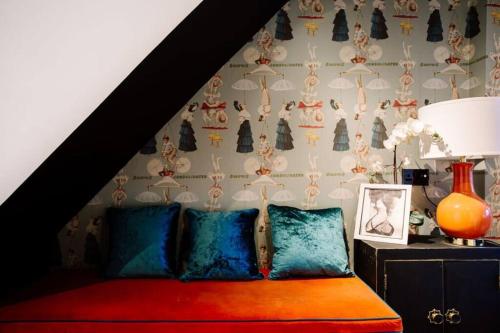 a bedroom with a bed with blue pillows and a wall at Modern & Stylish Home in the Heart of Belfast in Belfast