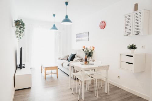 a white living room with a white table and chairs at Marimel Nerja Alojamientos in Nerja