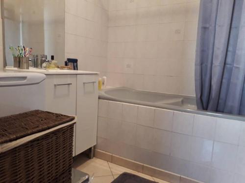 une salle de bain avec une baignoire et un lavabo et une baignoire dans l'établissement T4/5 avec vue sur les Alpes à 5 minutes de Lyon, à La Mulatière