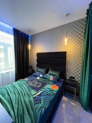 a bedroom with a bed with a black headboard at Apartments -Gold Glass Jacuzzi & Sauna Rynek Centrum -Parking -fakvat in Kielce