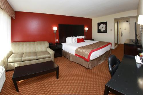 a hotel room with a bed and a couch at Ramada by Wyndham Fresno North in Fresno