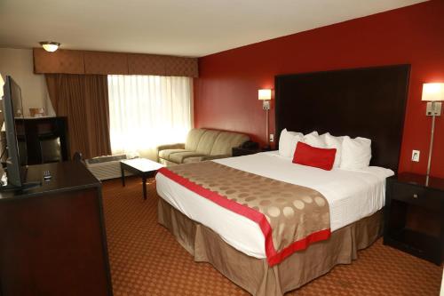 a hotel room with a large bed with a red wall at Ramada by Wyndham Fresno North in Fresno