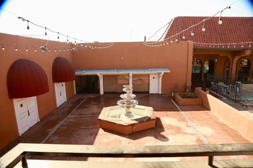 a large courtyard with a building with a fountain at Ramada by Wyndham Fresno North in Fresno