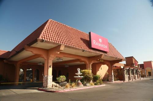 a building with a sign on the front of it at Ramada by Wyndham Fresno North in Fresno