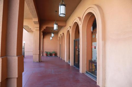 an empty hallway of a building with arches and lights at Ramada by Wyndham Fresno North in Fresno