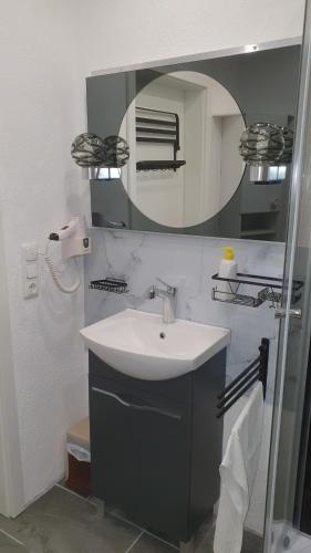 a bathroom with a sink and a mirror at Ferienwohnung Hofmann in Weisel