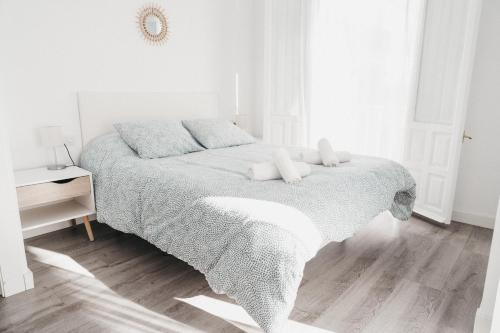 a white bedroom with a bed with two pillows at Marimel Nerja Alojamientos in Nerja