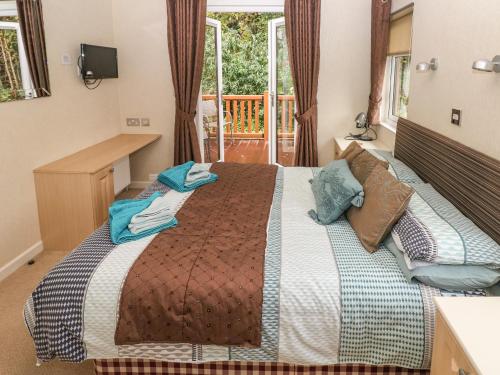 a bedroom with a bed with a desk and a window at 16 Heritage Park in Narberth