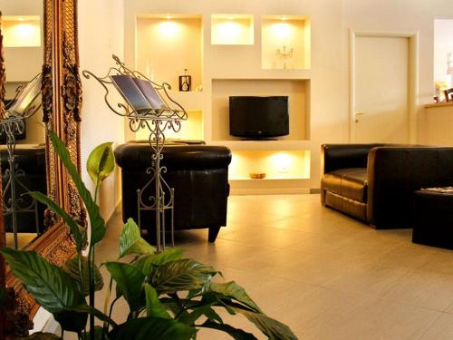 a living room with a couch and a tv at PFA Hotel La Darsena - Follonica in Puntone di Scarlino