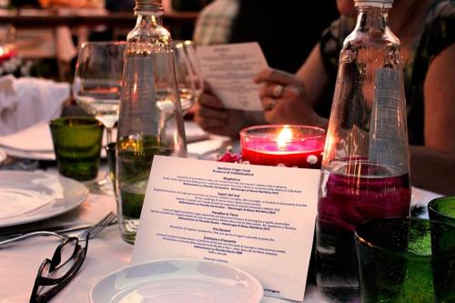 a table with a menu and a candle and glasses at PFA Hotel La Darsena - Follonica in Puntone di Scarlino