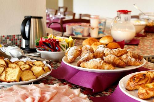 a table topped with plates of pastries and other foods at PFA Hotel La Darsena - Follonica in Puntone di Scarlino
