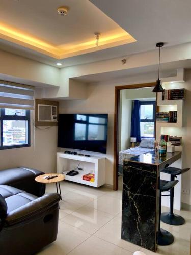Horizon 101 - champito's place في مدينة سيبو: غرفة معيشة بها أريكة وتلفزيون