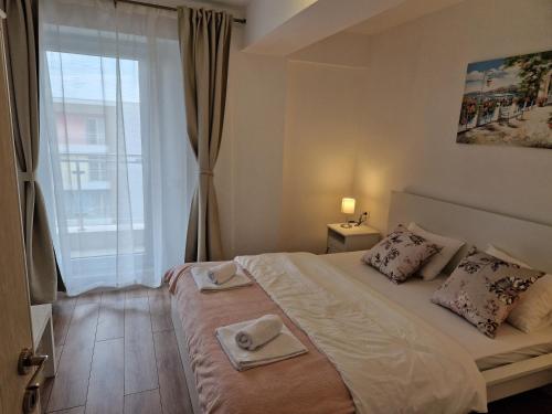 a bedroom with a bed with two towels on it at Teo Airport Residences in Otopeni