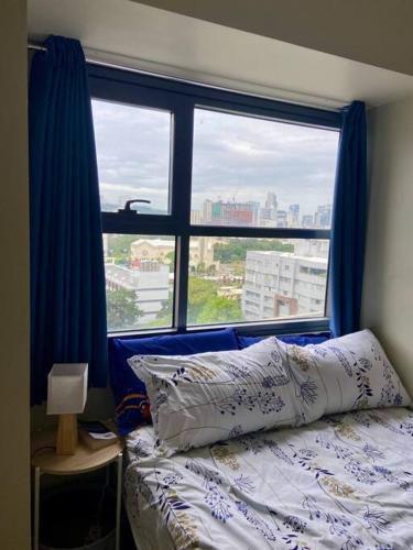 um quarto com uma cama e uma grande janela em Horizon 101 - champito's place em Cebu