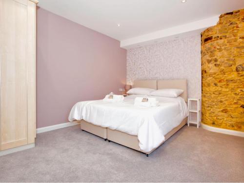 a bedroom with a large white bed with two towels at Lovely 2-Bed Apartment Colyton, nr. Jurassic Coast in Colyton