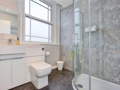 a bathroom with a toilet and a glass shower at Lovely 2-Bed Apartment Colyton, nr. Jurassic Coast in Colyton