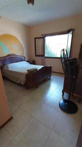 1 dormitorio con 1 cama, 1 silla y 1 ventana en Casa Timbó, en Piriápolis