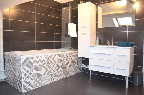 La salle de bains est pourvue d'une baignoire et d'un lavabo. dans l'établissement Le Cocon Troyen - 6-8P - 2 Parking Gratuits, à Troyes