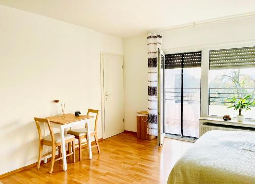 een slaapkamer met een bed en een tafel en stoelen bij Schöne Wohnung mit Balkon in Heidelberg in Heidelberg