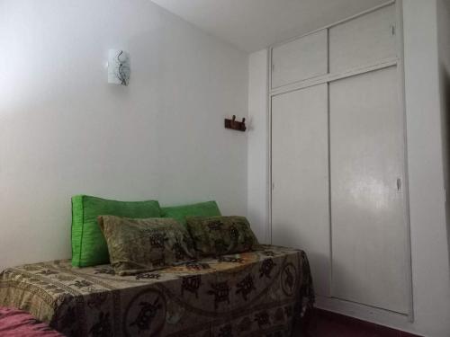a bedroom with a bed with green pillows on it at El Paso in Santa Clara del Mar