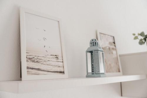 a shelf with two pictures and a bottle on it at Marimel Nerja Alojamientos in Nerja
