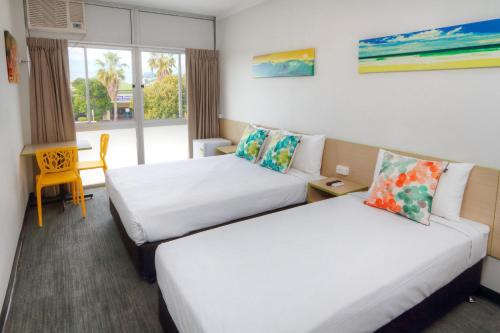 a hotel room with two beds and a window at Palm Beach Hotel in Gold Coast