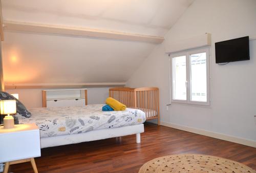 - une chambre avec un lit et une télévision murale dans l'établissement Le Cocon Troyen - 6-8P - 2 Parking Gratuits, à Troyes