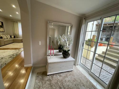 a living room with a mirror and a table with flowers at Casa da Grota in Porto Moniz