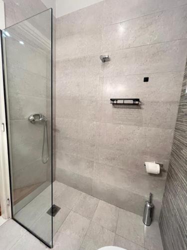uma casa de banho com um chuveiro e uma porta de vidro em Sm Athens em Atenas