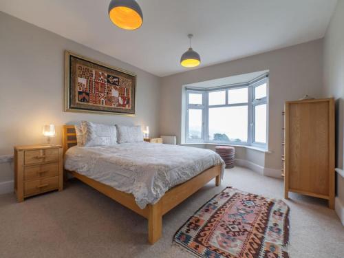 een slaapkamer met een groot bed en een raam bij Holme Cleve - enjoy the best view of Lyme Regis in Lyme Regis