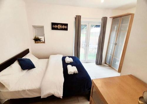 a bedroom with a bed with two towels on it at Three bed Ensuites in Edgware in Edgware
