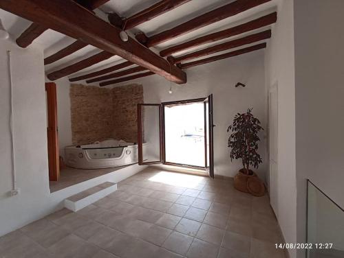 ein leeres Zimmer mit einem Fenster und einer Pflanze in der Unterkunft Casa de pueblo, entre mar y montaña, con spa. Plaza Mayor in Sant Jordi