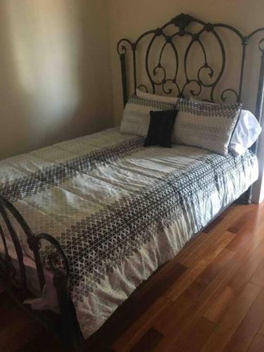 een bed met een metalen hoofdeinde en kussens erop bij Lovely one bedroom with free parking in Schenectady