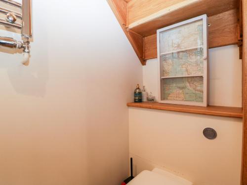 a bathroom with a map above a toilet at Barn Cottage in Leominster