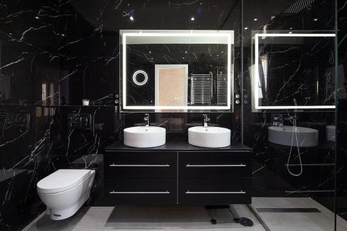 ein Badezimmer mit zwei Waschbecken und einer Toilette und einem Spiegel in der Unterkunft Espectacular villa close to Sevilla - Sevillarooms in Valencina de la Concepción