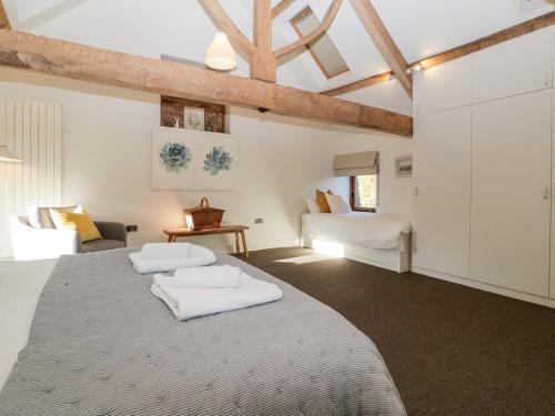 萊明斯特的住宿－Barn Cottage，一间卧室配有一张带两条白色毛巾的床