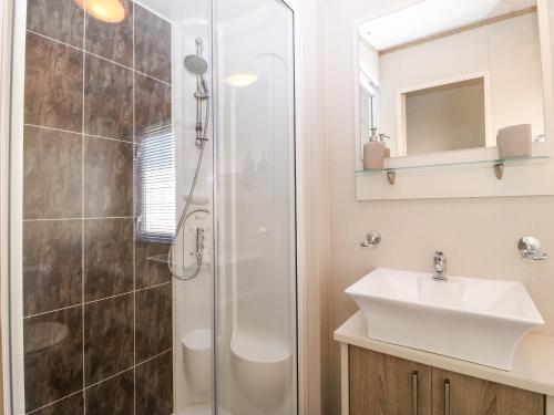 a bathroom with a shower and a sink at Snape Lodge in Abergele
