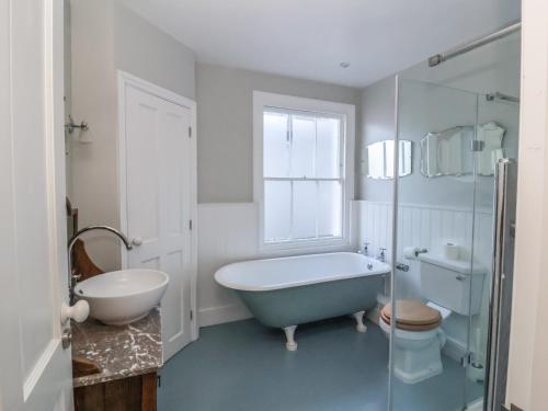 a bathroom with a tub and a toilet and a sink at Osprey in Southwold