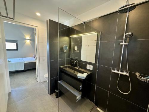 a bathroom with a sink and a shower at Salt Apartments Bonaire in Kralendijk