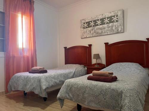 una camera da letto con due letti con asciugamani sopra di Casa Romántica a El Paso