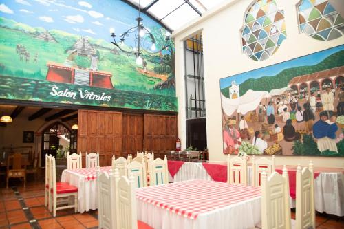 Un comedor con mesas blancas y sillas blancas. en Hotel D’Monica, en San Cristóbal de Las Casas