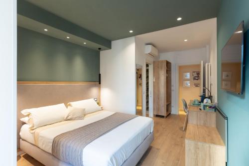 Un dormitorio con una gran cama blanca y una mesa en B&B Amadema, en Sorrento