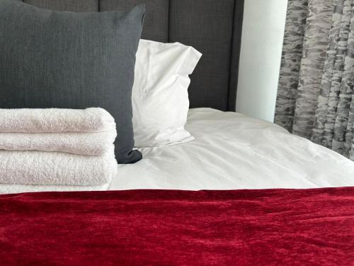 a bed with white sheets and a red blanket at Lilly's Gold in Johannesburg