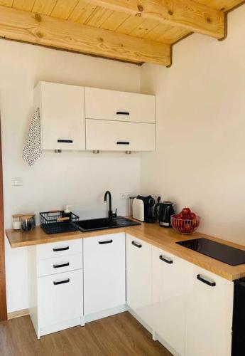 a kitchen with white cabinets and a wooden counter top at Bieszczadzkie Ukojenie in Ropienka