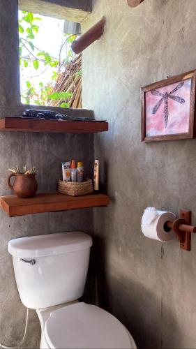 a bathroom with a white toilet and a window at CASA AUM in Brisas de Zicatela