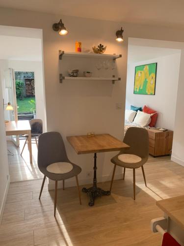 un salon avec une table et des chaises et un lit dans l'établissement La Plage, à Dunkerque