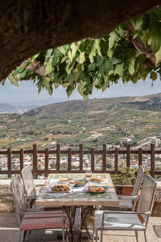 a table with plates of food on top of a balcony at Earino in Kato Asites